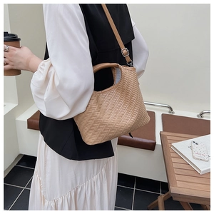 Close-up of woven bucket bag featuring detailed texture and adjustable shoulder strap