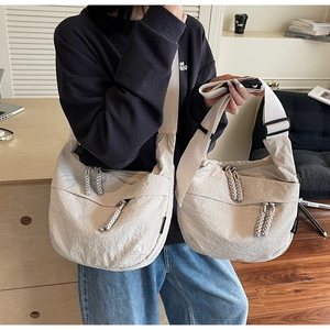 Detailed comparison of large and small beige nylon crossbody dumpling bags in daily use
