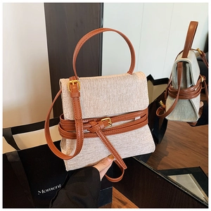 Détails du sac bandoulière en toile beige avec bordure en cuir brun et boucles dorées