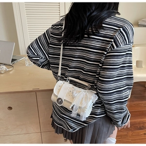 Detailed back view of white woven crossbody bag with lace trim and pearl accents