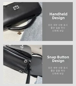 Detail of black matte leather handbag showing top handle and silver metal snap closure