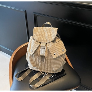 Detailansicht des khakifarbenen Karo-Rucksacks mit Kordelzug und seitlichen Knopftaschen