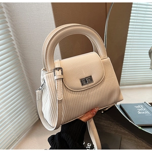 Detail of off-white leather bucket bag with vertical stitching and silver twist lock