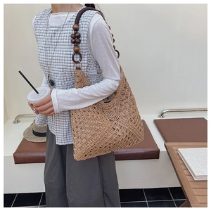 Detail of hand-woven crochet tote bag with geometric patterns and wooden bead shoulder strap