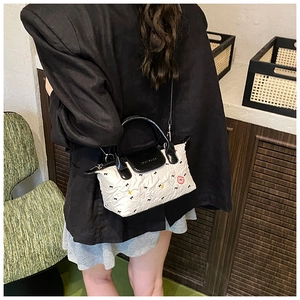 Dettaglio della mini borsa a tracolla bianca plissettata con ricamo di orsetti