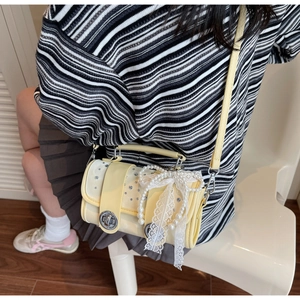 Close-up of woven crossbody bag featuring lace bows, pearls, and rhinestones in soft yellow