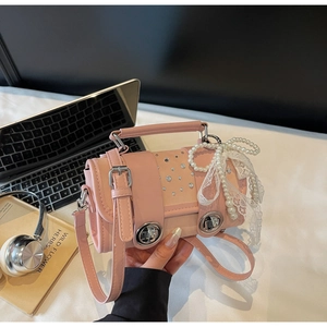 Detailed view of a pink woven mini bag with pearl bow, rhinestones, and lace accents