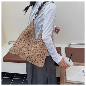 Detail of hand-crocheted khaki straw tote bag with geometric hollow weave and wooden beads