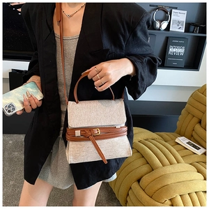 Détails du sac tissé avec finitions en cuir marron et boucle en métal doré