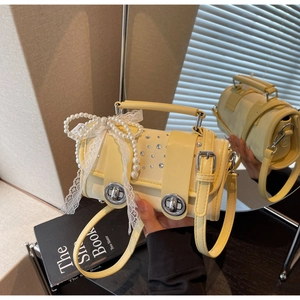 Detail of yellow woven bag with pearl bow, lace ribbons and sparkling rhinestone accents