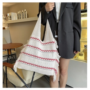 Detail of the woven cotton texture with red wave patterns and fringe on the tote bag