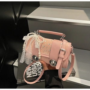 Detail of pink cylindrical woven bag with pearls, lace bow, and sparkling rhinestones