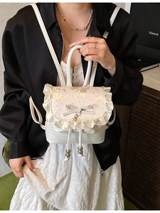 Mini cream backpack with ballet-style lace ruffles, bow detailing and pearl charm