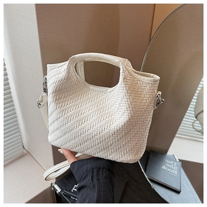 Detail of white woven bucket bag featuring integrated handle and silver metal hardware