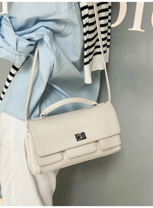 Chic off-white square flap bag featuring metal swivel lock and elegant top handle strap