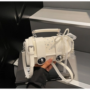 Detail of white cylinder woven bag with rhinestones, pearl bow and lace accents