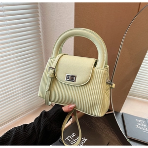 Detail of light green pleated handbag with silver twist lock and round handle