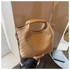 Detailed shot of khaki woven leather tote bag with metallic buckle and handle