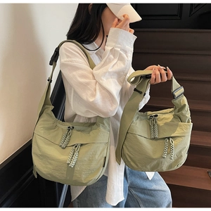 Detail view of grass green nylon crescent bags with adjustable straps and buckles