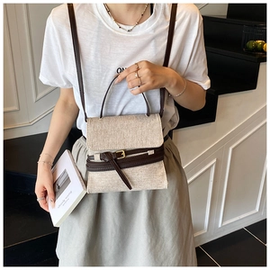 Détail du sac à bandoulière en toile avec lanières en cuir et boucle dorée en décor