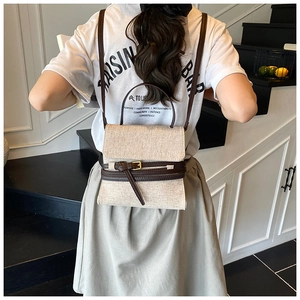 Détail d'un sac à dos en toile beige avec lanières en cuir marron sur mannequin