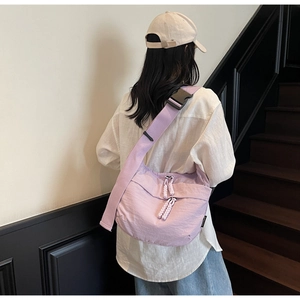 Rear view of a large purple nylon crossbody bag with adjustable wide shoulder strap