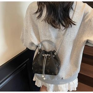 Detail of black marble textured bucket bag with pearl charms and silver metal ring handle