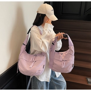 Close-up of light purple nylon dumpling bag with woven drawstring zipper pulls and strap