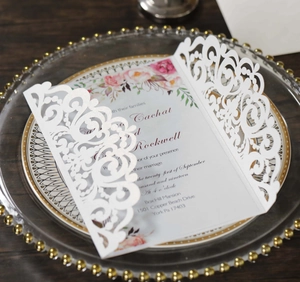 Détail d'invitation de mariage découpée au laser blanc avec insert floral sur plateau