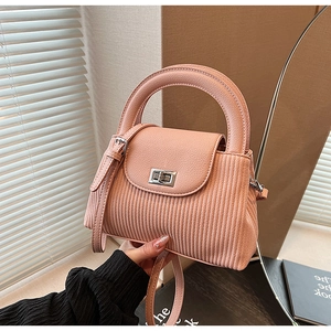 Close-up of pink pleated fabric bag featuring leather handle and silver metal turn-lock
