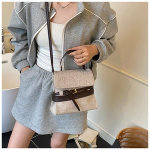 Détails du sac en toile beige avec lanières en cuir marron et boucles dorées élégantes