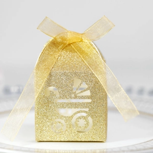 Detail of glittery gold baby shower favor box with hollow stroller design and ribbon bow