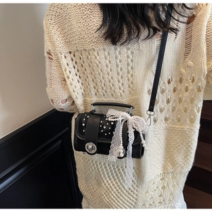 Black woven mini bag shown cross-body with white pearls and lace bow detail