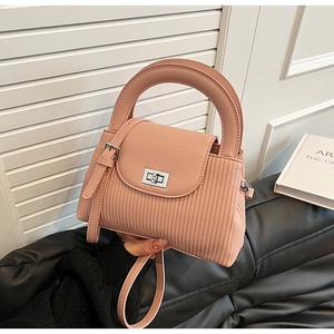 Detail of pink pleated bucket bag with silver twist lock and round carry handle