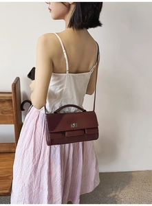 Deep red leather bag with silver metal square turn lock and adjustable shoulder strap