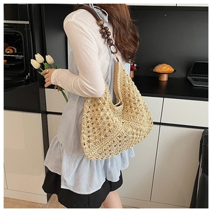 Detail of hand-woven straw tote with vintage wooden beads on the shoulder strap