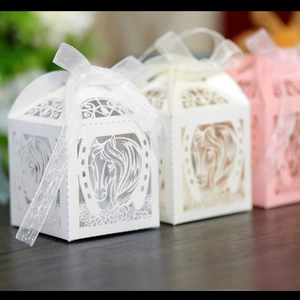 Détail de motifs de chevaux découpés au laser et rubans d'organza sur boîtes à bonbons