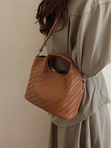 Brown woven leather tote bag for women featuring a minimalist bucket style with top handle