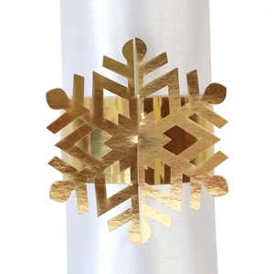 Close-up of golden snowflake napkin ring with a reflective metallic finish and intricate laser cut