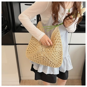 Detail of handwoven straw tote bag showing intricate hollow crochet texture and beige fibers