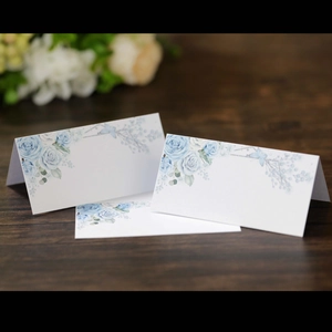 Elegant white floral place cards with blue roses for weddings and formal parties