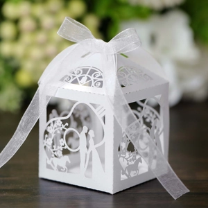 Détail boîte de mariage découpée au laser blanche avec motif silhouette et ruban blanc