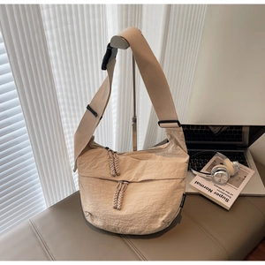 Macro detail of beige nylon moon bag with woven zipper puller and canvas strap
