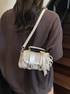 Silver woven crossbody bag with pearl lace bow and dual circular locks for women