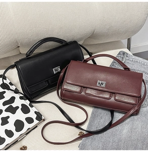 Detail of classic black and burgundy leather handbags with silver twist locks on a sofa