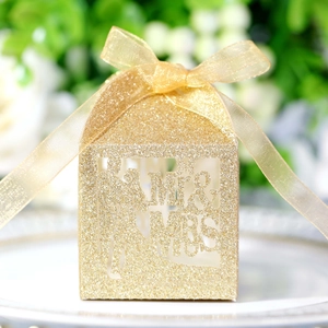 Detail of laser-cut Mr & Mrs gold glitter wedding favor box with a satin ribbon bow