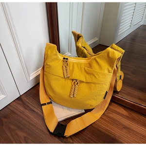 Detail shot of bright yellow nylon crescent crossbody bag with adjustable wide strap and buckle