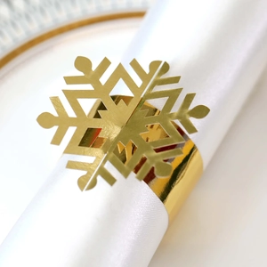 Macro shot of gold snowflake napkin ring on a white linen napkin for table decor