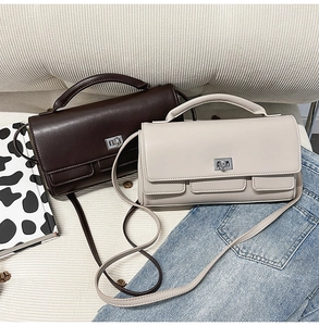 Chic dark coffee and cream white square handbags with silver twist locks on sofa