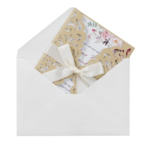 Détail de l'invitation de mariage dorée découpée au laser avec carte rose et ruban